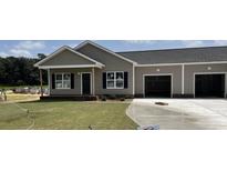 Newly constructed home with gray siding, two-car garage, and a front yard at 66 Kevior Ave, Four Oaks, NC 27524