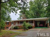 Brick ranch home with attached carport and landscaped yard at 1133 Evans Rd, Cary, NC 27513