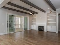 Spacious living room featuring hardwood floors, a fireplace, and built-in shelving at 1117 Old Lystra Rd, Chapel Hill, NC 27517