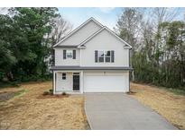 Two-story home with attached garage and neutral color scheme at 411 N Mckay Ave, Dunn, NC 28334