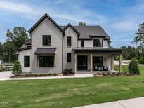 Two-story home with a gray brick exterior and a welcoming front porch at 904 Havens Edge Ct, Apex, NC 27523