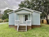 Charming light blue single story home with a covered porch and steps at 1304 Queen Ann St, Burlington, NC 27217