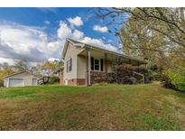 Ranch-style house with a detached garage and a front porch at 1054 George Bason Rd, Graham, NC 27253