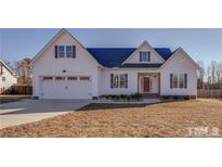 White farmhouse style home with gray shutters and a red door at 255 Baptist Grove Rd, Fuquay Varina, NC 27526