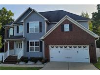 Two-story house with gray and brick exterior and three car garage at 50 Barlowe Ct, Cameron, NC 28326