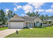Tan one-story house with a two-car garage and landscaped lawn at 112 Holly Oak Cir, Bunnlevel, NC 28323
