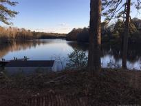 Serene waterfront view with private dock and boathouse at 4191 Swanns Station Rd, Sanford, NC 27332