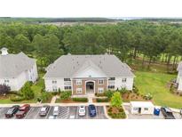 Aerial view of condo building with parking and surrounding landscape at 288 Gallery Dr # 204, Spring Lake, NC 28390