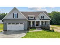 Gray two-story home with a white garage door and landscaped yard at 57 Woodbark Cv # 9, Willow Springs, NC 27592