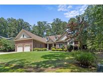 Brick ranch home with a three-car garage and manicured lawn at 595 Chelsea Dr, Sanford, NC 27332