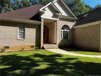 Brick house with a brown roof, and a walkway at 1977 Putters Cir, Sanford, NC 27332