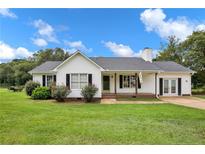 White house with gray roof, porch, and green lawn at 585 Bill Avery Rd, Coats, NC 27521