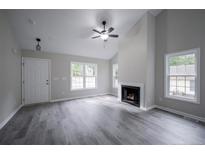 Bright living room featuring vaulted ceiling, fireplace, and vinyl plank flooring at 1050 Upland Reach, Sanford, NC 27332