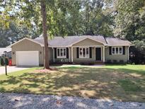 Ranch style home with a green exterior and attached garage at 5056 Bluebird Dr, Sanford, NC 27332