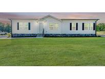 White single-wide home with black shutters, stone accents, and a large green lawn at 849 Loop Rd, Bunnlevel, NC 28323