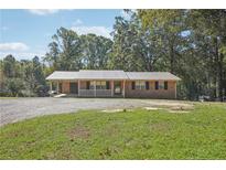 Brick ranch house with covered porch and large yard at 1136 Pumping Station Rd, Sanford, NC 27330