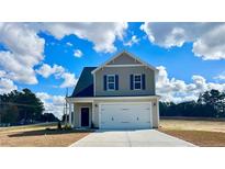 Two-story house with a neutral exterior, two-car garage, and a well-maintained lawn at 15 Red Bird Dr, Cameron, NC 28326