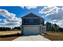 Two-story house with gray siding, white garage door, and landscaped yard at 29 Red Bird Dr, Cameron, NC 28376