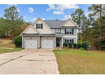Two-story house with a three-car garage and landscaped yard at 58 Shortleaf Ct, Cameron, NC 28326