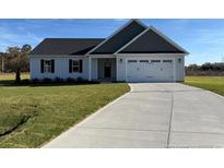 Ranch style home with gray and white siding and a driveway at 109 Mossy Bridge Ct, Lillington, NC 27546