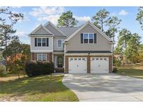 Two story house with a three car garage and manicured lawn at 20 Lakeforest Trl, Sanford, NC 27332