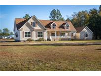 Charming two-story home with a large front lawn and mature trees at 1471 Nc 24 Hwy, Cameron, NC 28326