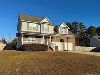 Two-story brick home with a landscaped yard and attached garage at 185 Swain St, Spring Lake, NC 28390