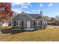 Gray house with white trim, landscaping, and a spacious lawn at 900 N Orange Ave, Dunn, NC 28334