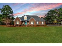 Brick home with landscaped lawn and large backyard at 545 Adcock Rd, Lillington, NC 27546