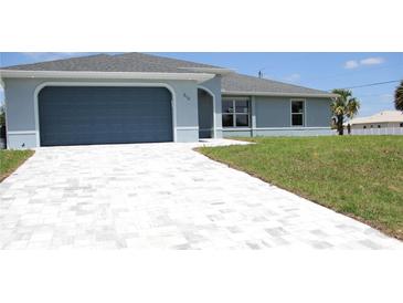 Charming single-Gathering home with a grey finish, concrete tile driveway, and manicured lawn at 310 Day Break Cir, Port Charlotte, FL 33954