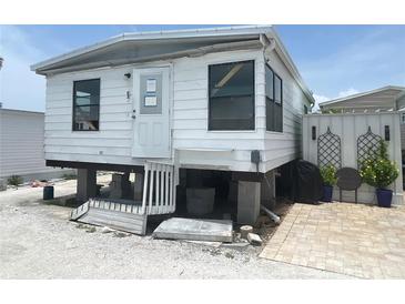 Exterior view of raised single story home with white siding and small front porch at 3710 Gulf Of Mexico Dr # E3, Longboat Key, FL 34228