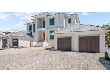 Beautiful two-story white home with a two-car garage, steps to front door, and gravel driveway at 3621 San Remo Ter, Sarasota, FL 34239