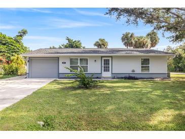 Charming single-story home with a well-maintained lawn and mature landscaping at 301 Lambert St, Port Charlotte, FL 33948