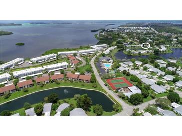 Aerial view of waterfront community with tennis courts and pool at 4523 Independence Dr, Bradenton, FL 34210