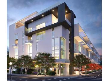 Modern building featuring large windows and private balconies, set amidst landscaped street and illuminated by street lights at 1305 4Th St # 501A, Sarasota, FL 34236