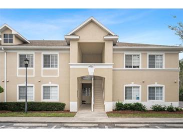 Tan two-story condo building with stairs and landscaping at 9505 Amberdale Ct # 201, Riverview, FL 33578