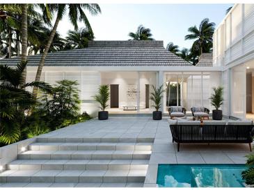 A stunning outdoor patio area featuring modern furniture, lush tropical plants, and a sparkling swimming pool, perfect for relaxation at 540 Givens St, Sarasota, FL 34242