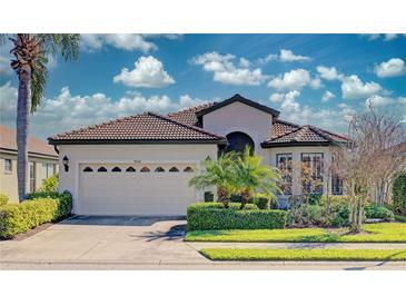 One-story house with beige exterior, a three-car garage, and tropical landscaping at 8146 Stirling Falls Cir, Sarasota, FL 34243
