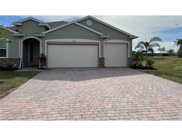 Two-car garage and paver driveway with a neutral-colored exterior at 2275 Hamburg Ln, Punta Gorda, FL 33983
