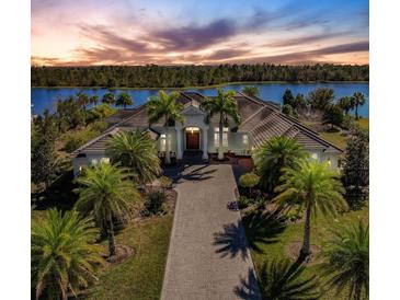 Luxury waterfront home with circular driveway and palm trees at 20910 Parkstone Ter, Bradenton, FL 34202