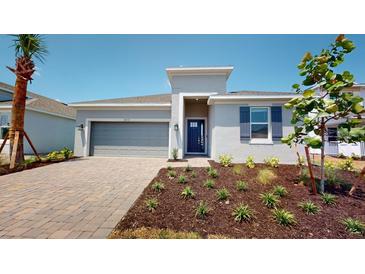A charming new home with gray exterior and a brick driveway at 16113 Old Fox Trl, Port Charlotte, FL 33953