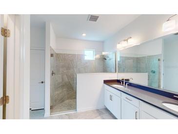 Modern bathroom with double vanity and large walk-in shower at 16145 Old Fox Trl, Port Charlotte, FL 33953