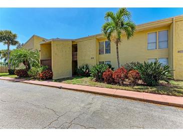 Building exterior showcasing yellow siding and palm trees at 3411 Clark Rd # 212, Sarasota, FL 34231