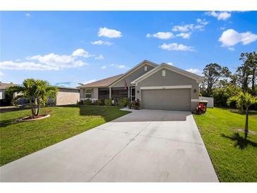 One-story home with gray siding and landscaping at 8499 Topeka Cir, Port Charlotte, FL 33981
