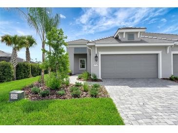 Two-car garage and walkway of a new home with landscaping at 2638 Light Sky Ln, Bradenton, FL 34211