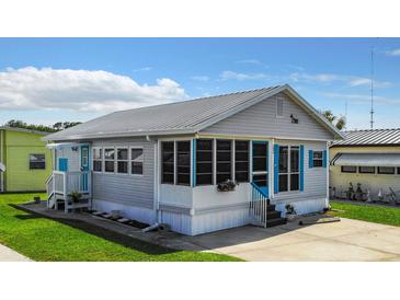 Charming single-Gathering home features a metal roof, screened-in porch, and light gray siding with blue shutters at 3333 26Th E Ave # 1099, Bradenton, FL 34208