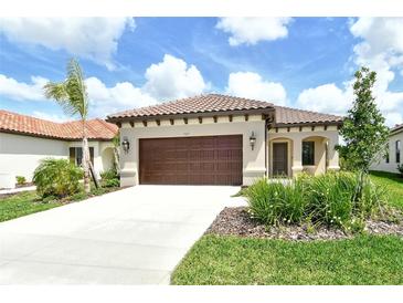 Charming single-story home featuring a tile roof, two-car garage, and lush landscaping at 305 Potenza Loop, Nokomis, FL 34275
