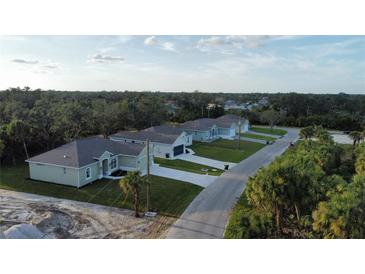 New construction homes with paved driveways and grassy yards at 8233 Givlic Ln, North Port, FL 34287