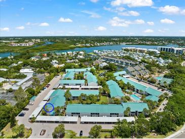 Aerial view of waterfront community, showing building, parking, and landscaping at 5641 Midnight Pass Rd # 902, Sarasota, FL 34242