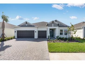 Beautiful single Gathering home featuring a well manicured lawn, a paver driveway, and two-car garage at 1580 Laurel Brook Ln, Port Charlotte, FL 33953